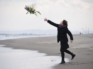 A woman throws flowers into the sea to pray for victims of the 2011 earthquake and tsunami in Sendai, northern Japan on March 11, 2016. Japan marked the fifth anniversary of the March 11 quake and tsunami that claimed some 18,500 lives, flattened coastal communities and set off the worst atomic crisis in a generation. / AFP / TORU YAMANAKA
